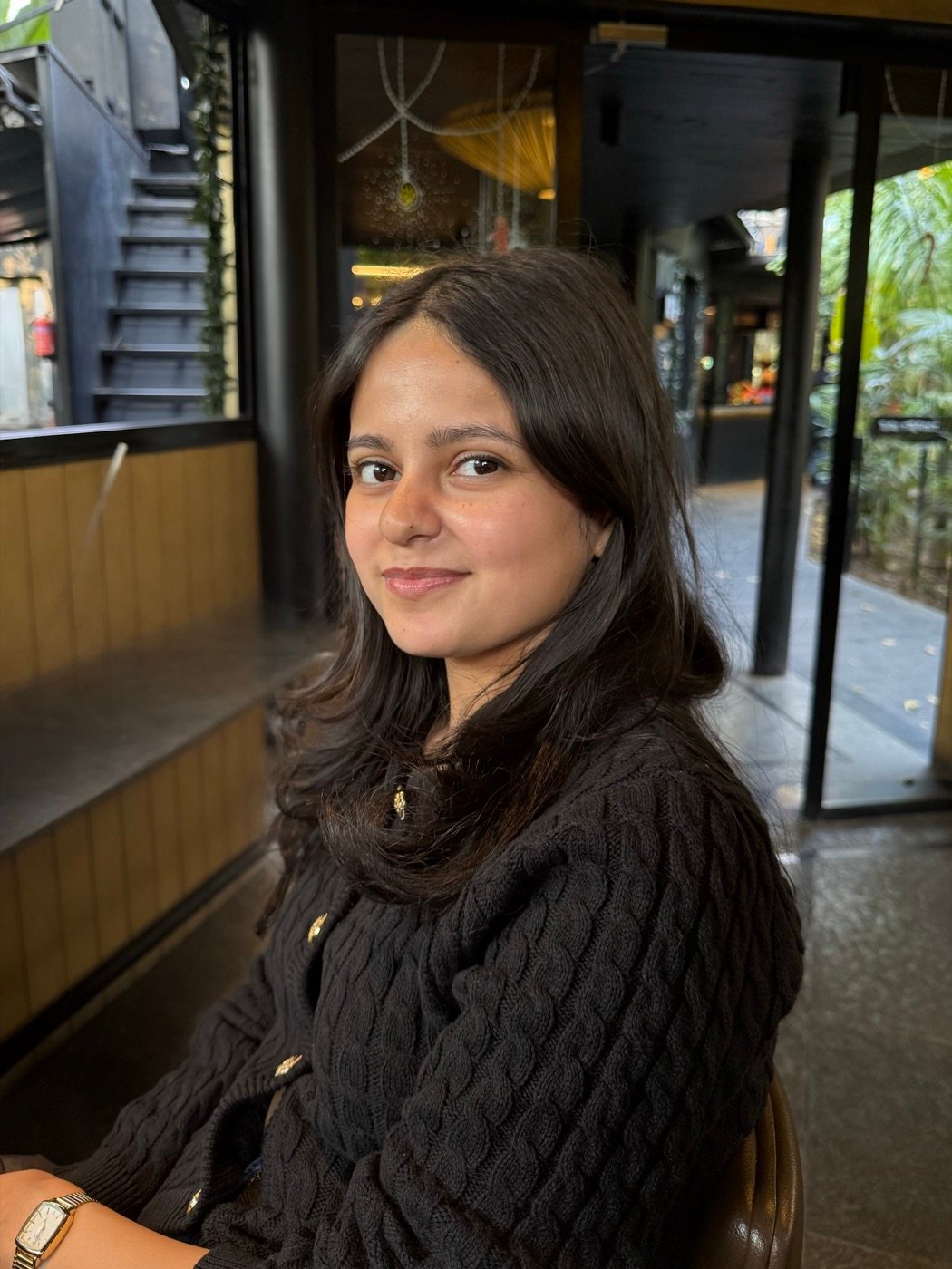 Ridhi smiling at a cafe